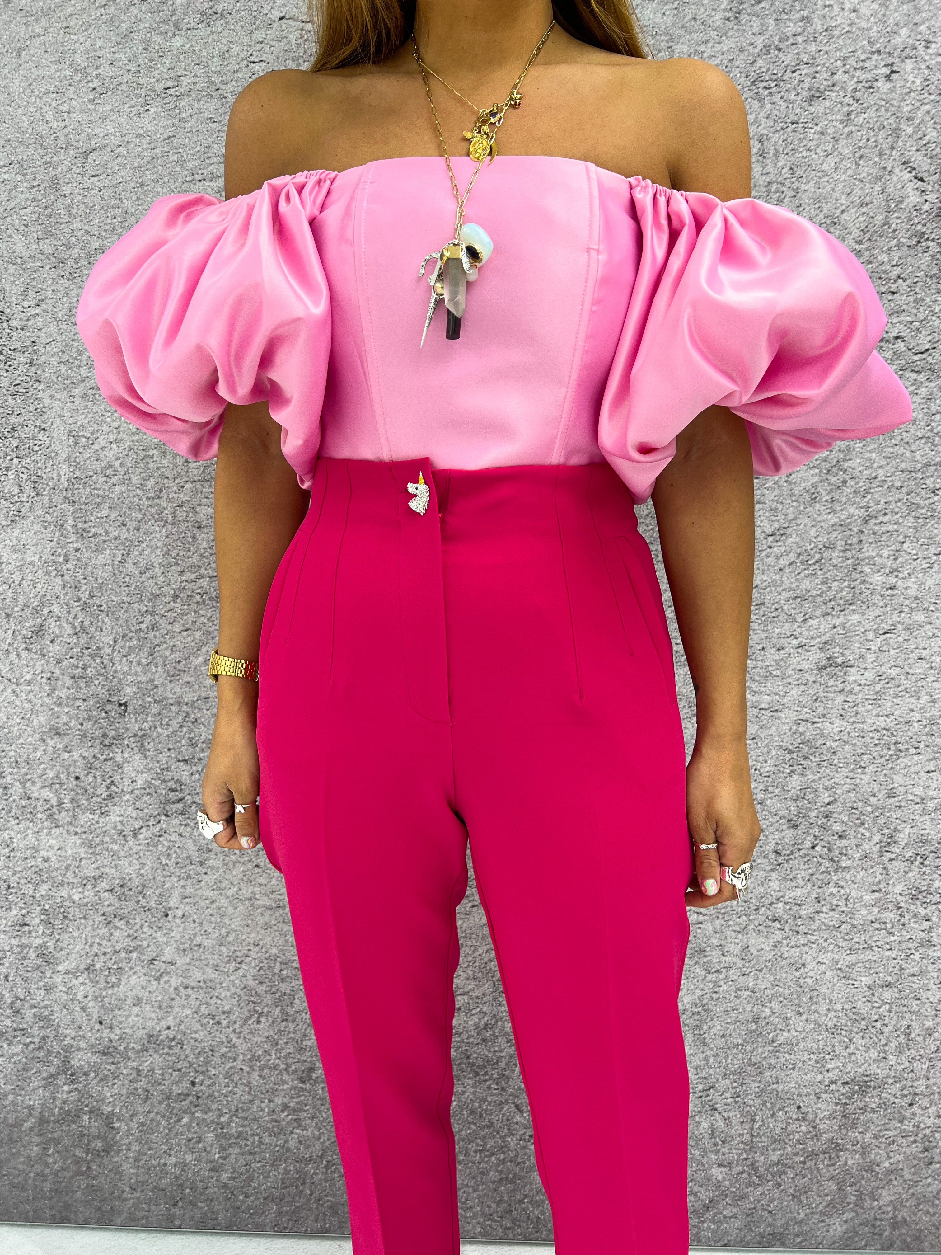 close up of pink satin puff sleeve top styled with hot pink trousers