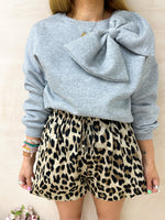 close up of model wearing drawstring waist Floaty High Waisted Shorts In Leopard Print styled grey sweatshirt