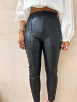 close up of model wearing High Waisted Leather Look button front skinny Trousers In Black styled with balloon sleeve button front white blouse 