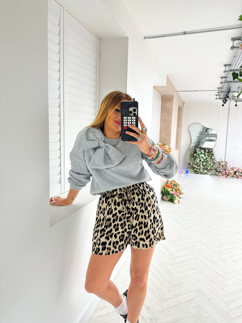 close up of model wearing drawstring waist Floaty High Waisted Shorts In Leopard Print styled grey sweatshirt