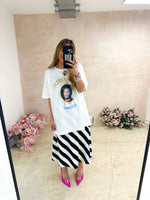 model wearing oversized t-shirt in white with Dr. Dre 'The Chronic' graphics, styled with horizontal stripe skirt in black and white