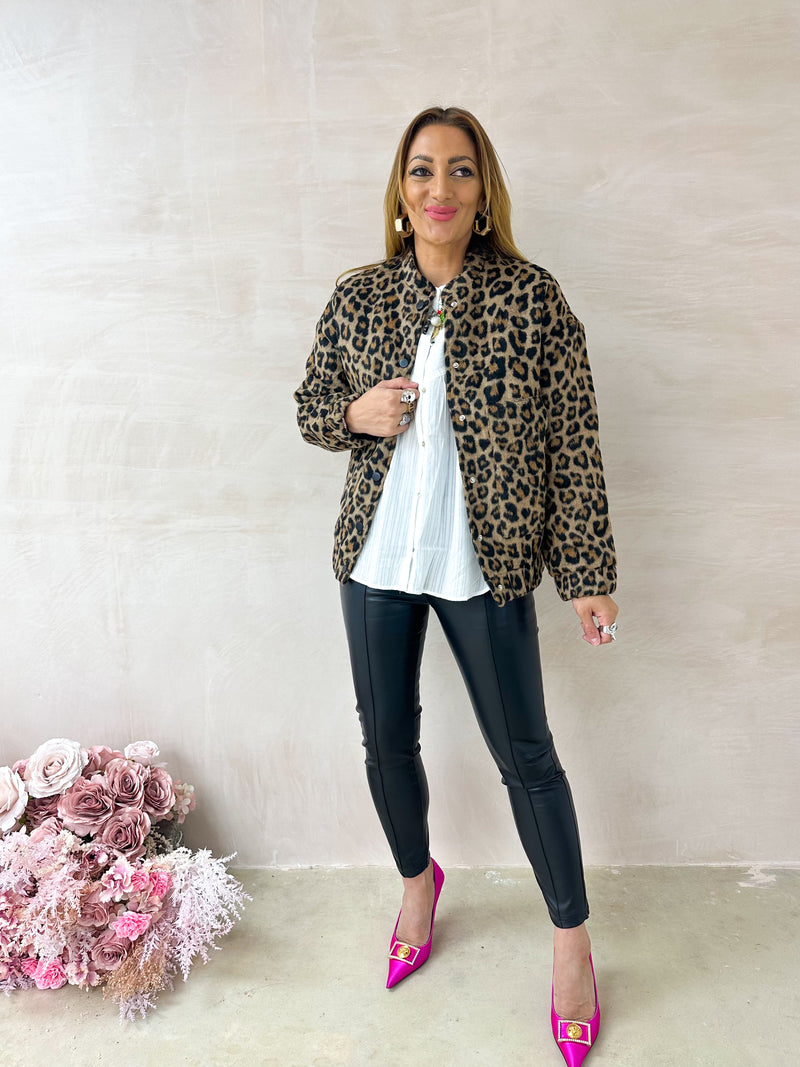 model wearing High Waisted Leather Look button front skinny Trousers In Black styled with balloon sleeve button front white blouse with leopard print bomber style jacket 