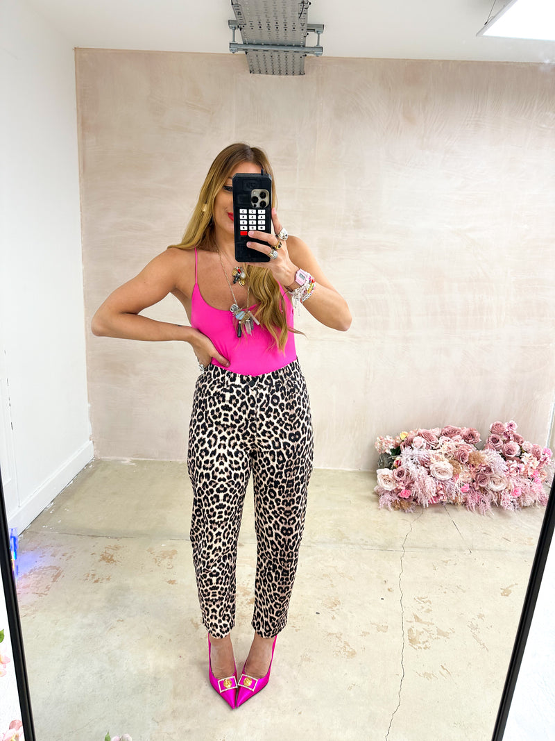 mirror selfie of model wearing hot pink lycra bodysuit with scoop neckline and thin straps styled with leopard print jeans