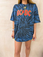 Model wearing a tie dye oversized graphic t-shirt featuring a AC/DC band logo