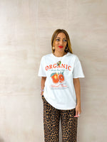  model wearing a white t-shirt with sliced orange graphics styled with leopard print trousers