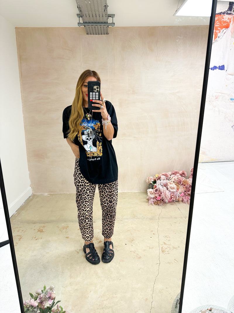 model wearing High Waisted button front Jeans In Leopard Print styled with oversized graphic t-shirt in black 